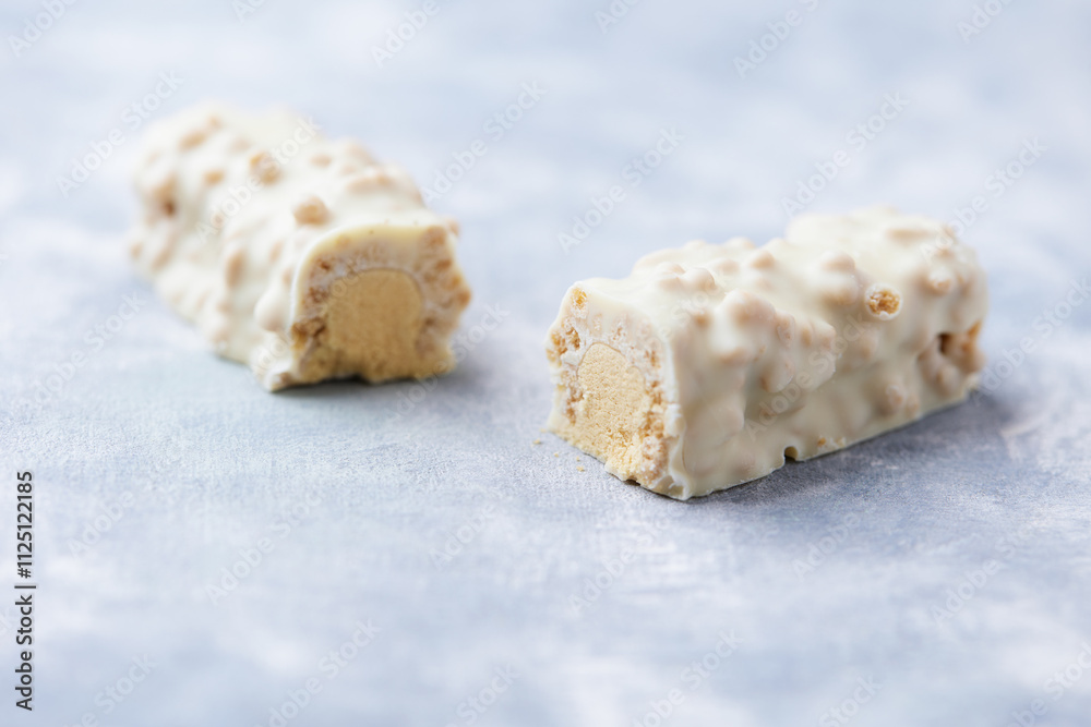 Protein bar in two pieces on wooden background. Soft focus. Close up. Copy space
Protein bar in two pieces on wooden background. Soft focus. Close up. Copy space