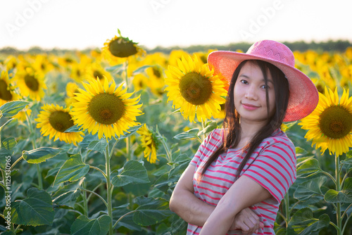 Portrait of beautiful asian girl in sunflower field at sunset. Beautiful asian woman in sunflower field at summer day.