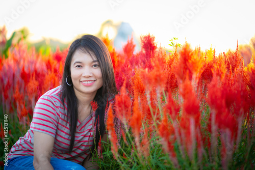 Portrait of beautiful asian girl in sunflower field at sunset. Beautiful asian woman in sunflower field at summer day.