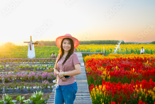 Portrait of beautiful asian girl in sunflower field at sunset. Beautiful asian woman in sunflower field at summer day.