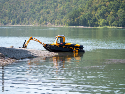 Abrau Durso, Russia 28 August 2024: Municipal aquatic weed harvesting equipment passes along lake Abrau-Durso
