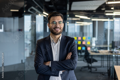 Wallpaper Mural A professional businessman standing confidently in a modern office setting with glass walls and bright lighting, exuding positivity and success. Torontodigital.ca