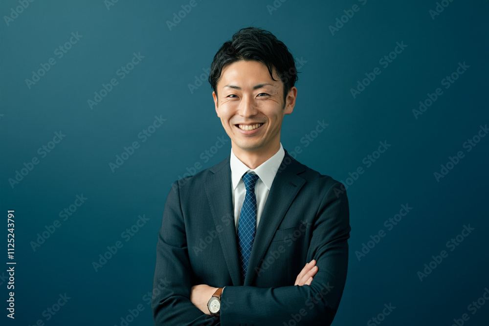 笑顔のビジネスマン 腕組み 青背景 30代 笑顔のビジネスマン 腕組み 青背景 30代