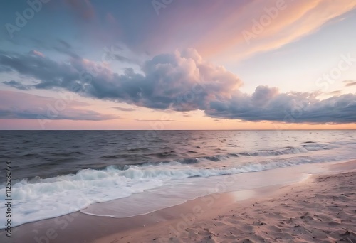 beach at sunset. Waves on the shore, a pastel sky with clouds over the ocean.