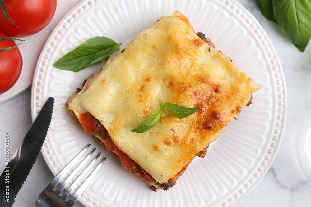 Delicious cooked lasagna with basil served on white marble table, flat lay Delicious cooked lasagna with basil served on white marble table, flat lay