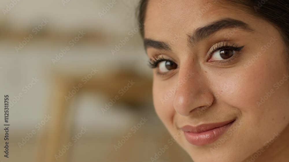 Close up face portrait smiling cheerful satisfied charming attractive beautiful happy healthy Indian woman Arabian girl lady female at home indoors looking at camera make up cosmetology dermatology