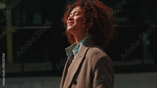A happy businesswoman walks through the city during her daily commute. She loves her work and life, and can't wait to start her day.