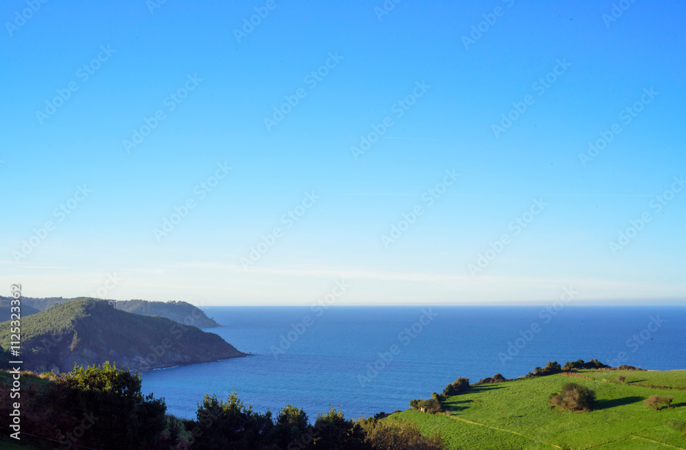 Bahía marina desde praderas verdes de hierba en costa de Asturias Bahía marina desde praderas verdes de hierba en costa de Asturias