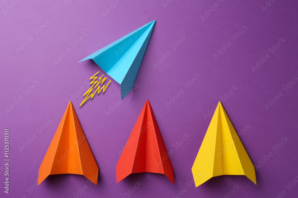 Light blue paper plane bursting forward among others on purple background Light blue paper plane bursting forward among others on purple background