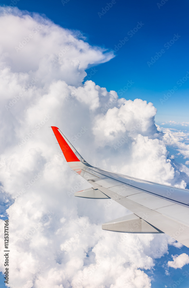 View from the airplane window at a beautiful cloudy sky and the airplane wing View from the airplane window at a beautiful cloudy sky and the airplane wing