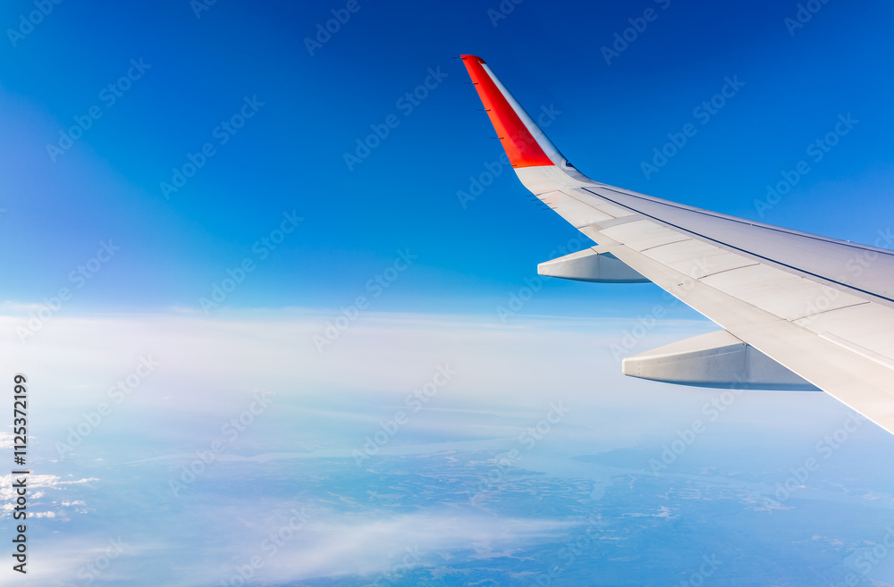 View from the airplane window at a beautiful cloudy sky and the airplane wing View from the airplane window at a beautiful cloudy sky and the airplane wing