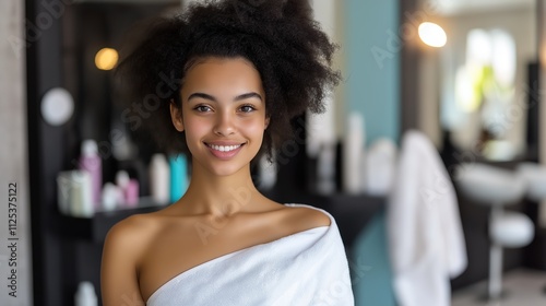 Woman with afro hair in spa towel against blurred interior. Natural beauty concept