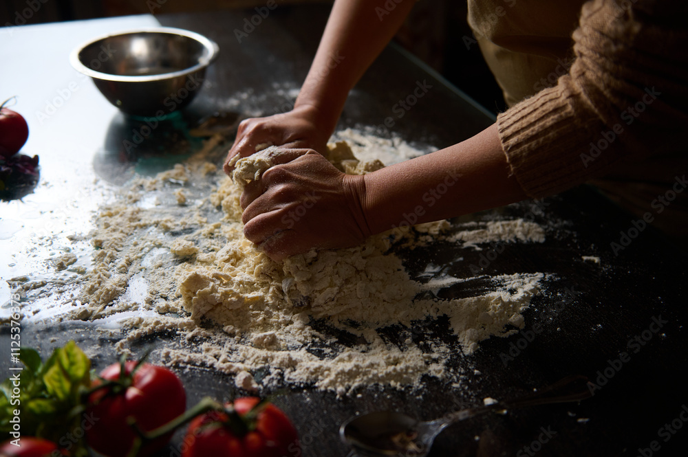 Hands kneading dough on a floured tabletop with fresh ingredients nearby Hands kneading dough on a floured tabletop with fresh ingredients nearby