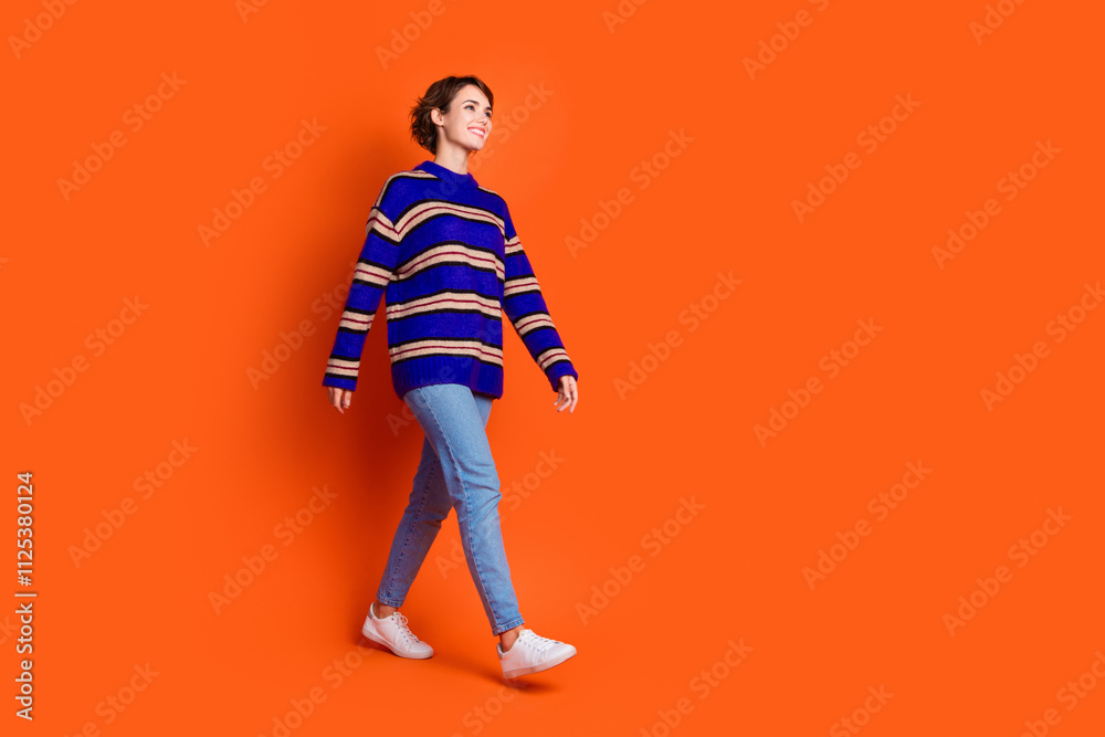 Photo of cheerful glad woman wear trendy clothes look empty space isolated on orange color background Photo of cheerful glad woman wear trendy clothes look empty space isolated on orange color background