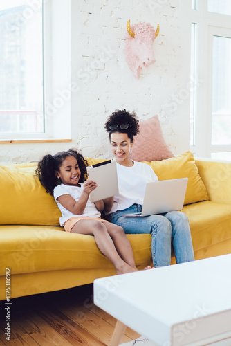 Mother and daughter spending time with laptop and tablet