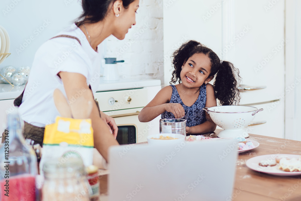 Happy ethnic child asking for sweets while mother cooking Happy ethnic child asking for sweets while mother cooking