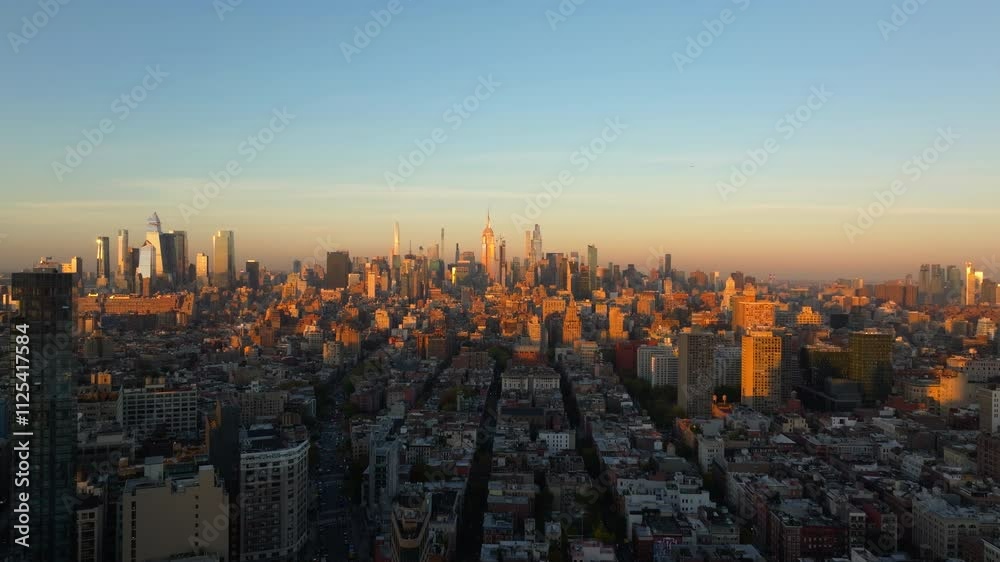 Bird's eye view of warm sunlight enveloping New York City's buildings of Midtown Manhattan, painting skyline with vibrant hues during golden hour Bird's eye view of warm sunlight enveloping New York City's buildings of Midtown Manhattan, painting skyline with vibrant hues during golden hour