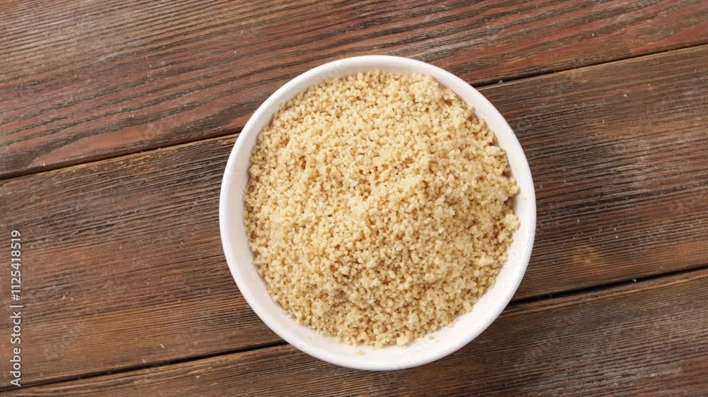 cooked couscous in bowl rotation top view wooden surface cooked couscous in bowl rotation top view wooden surface