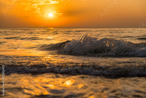 Aufnahme von einer brechenden Welle im Sonnenlicht, am Meer.