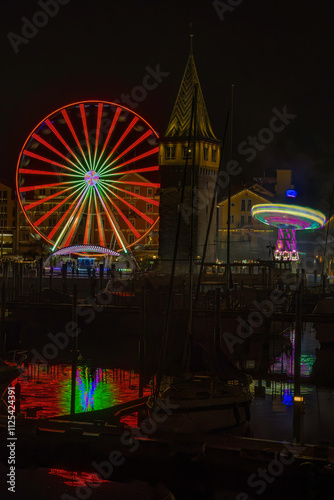 Aufnahme von einem Jahrmarkt mit großem, farbigen Riesenrad und einem Kettenkarusell. photo