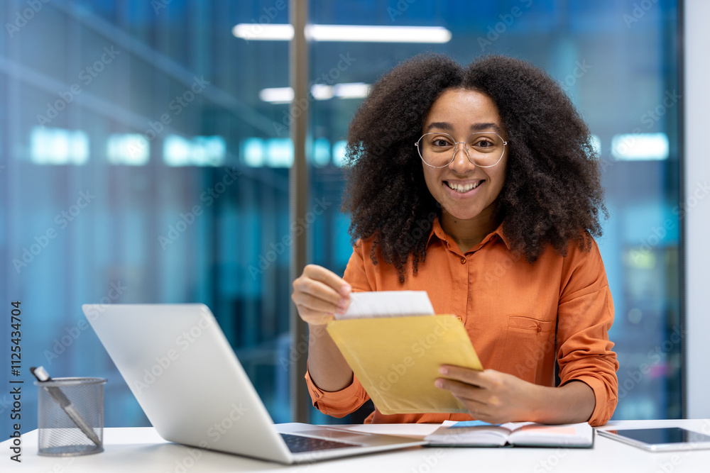 Smiling woman in an office setting, holding an envelope, sitting at a desk with a laptop and notebooks. The scene conveys professionalism, focus, and a positive working environment. Smiling woman in an office setting, holding an envelope, sitting at a desk with a laptop and notebooks. The scene conveys professionalism, focus, and a positive working environment.