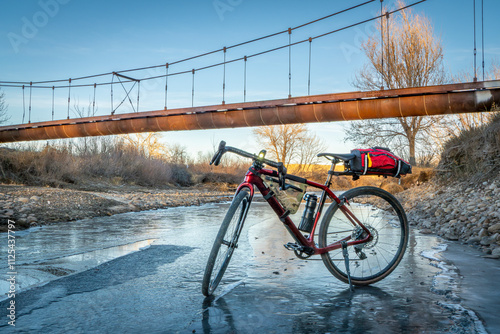 touring gravel bike on a shory of partially frozen Poudre River in Fort Collins, Colorado photo