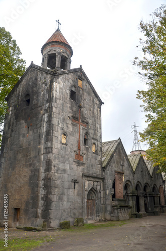 An ancient stone Sanahin monastery stands amidst a lush green forest, showcasing historical architecture. Armenia photo