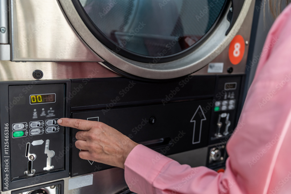 Fototapeta premium Close up picture of female hand programming washing machine