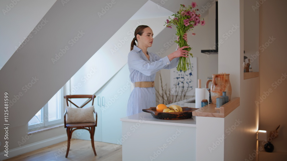Elegant housewife putting flowers vase decorating home. Woman sniffing bouquet Elegant housewife putting flowers vase decorating home. Woman sniffing bouquet