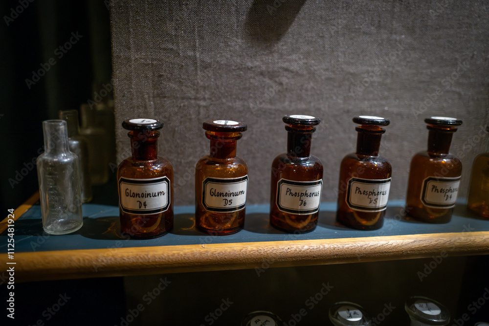 There are several small old pharmacy bottles on a shelf