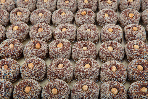 Sekerpare, Traditional Turkish Dessert with Poppy Seeds and Hazelnuts. Freshly baked Turkish dessert sekerpare with syrup on a tray. photo