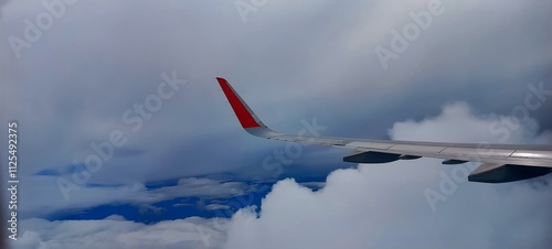 Airplane in the cloudy sky, view from the airplane window.