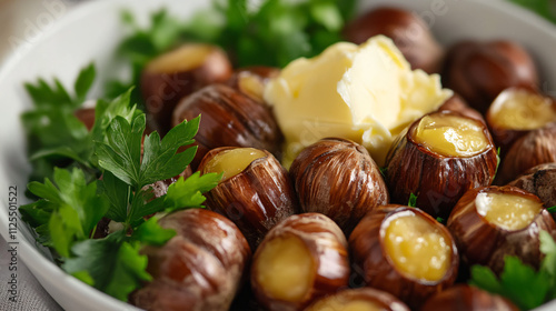 Roasted chestnuts served with a side of creamy butter and fresh parsley for garnish. photo