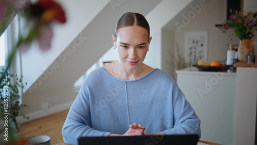 Closeup relaxed girl videocalling in domestic atmosphere closeup. Earphones lady photo