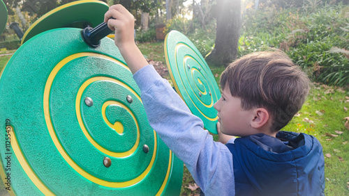 Large children's sensory toys on the playground and the child who plays with them. Concept of development of fine motor skills, Montesori for children outdoors