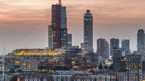 Aerial day to night transition timelapse of Katendrecht peninsula and Maashaven harbour in Rotterdam, The Netherlands. City skyline modern skyscrapers and traditional Dutch waterfront houses photo