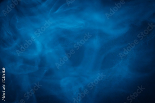 A close-up of soft, swirling blue smoke patterns creating an ethereal and dreamy abstract effect against a dark background