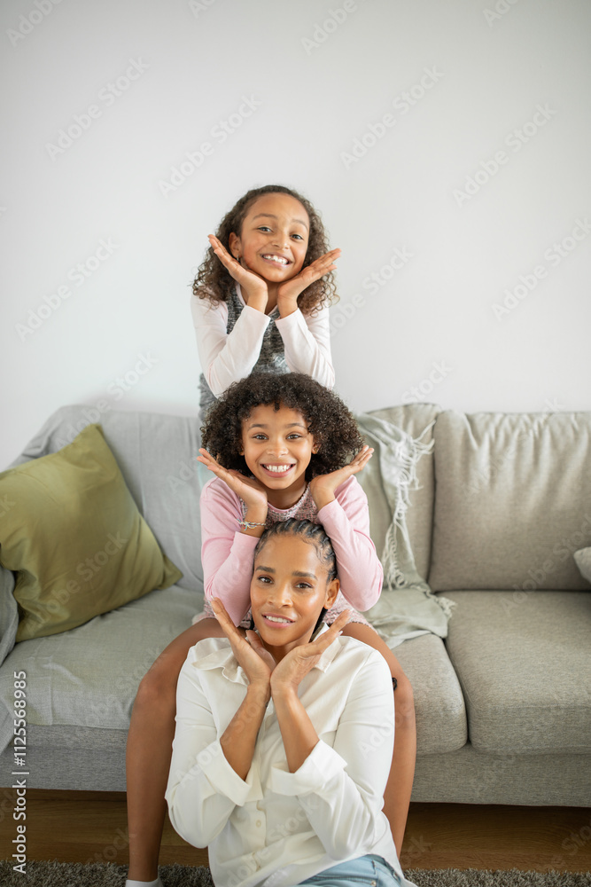 Two daughters pose playfully at home, showcasing their affection for their mother. The warm atmosphere reflects love and care, with smiles highlighting their close bond. Two daughters pose playfully at home, showcasing their affection for their mother. The warm atmosphere reflects love and care, with smiles highlighting their close bond.