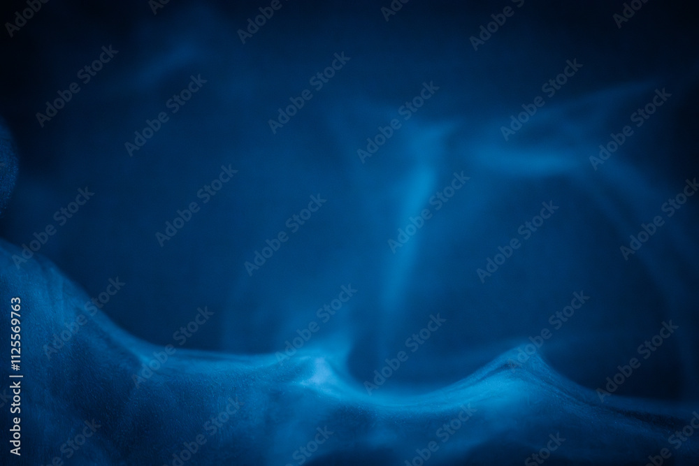 A close-up of soft, swirling blue smoke patterns creating an ethereal and dreamy abstract effect against a dark background A close-up of soft, swirling blue smoke patterns creating an ethereal and dreamy abstract effect against a dark background