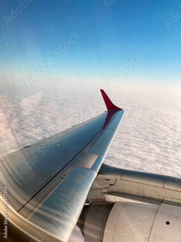 Airplane Wing Over Clouds With Red Tip
