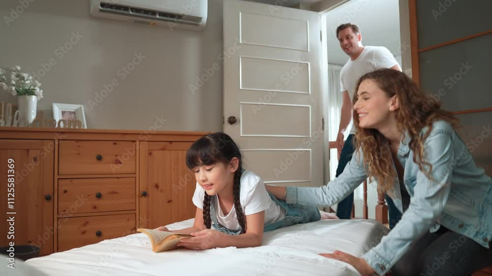 Bedtime story with childhood storytelling, mom and dad reading a fantasy book together to their little young girl in cozy and comfortable bedroom. Modern family happy time. Fastidious Bedtime story with childhood storytelling, mom and dad reading a fantasy book together to their little young girl in cozy and comfortable bedroom. Modern family happy time. Fastidious