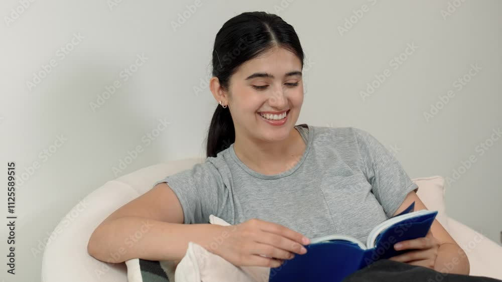 Woman sitting on sofa indoor reading textbook increase knowledge about social and technology for occupation or raise children to be good adult as smart mother. Lifelong learning concept. Divergence. Woman sitting on sofa indoor reading textbook increase knowledge about social and technology for occupation or raise children to be good adult as smart mother. Lifelong learning concept. Divergence.