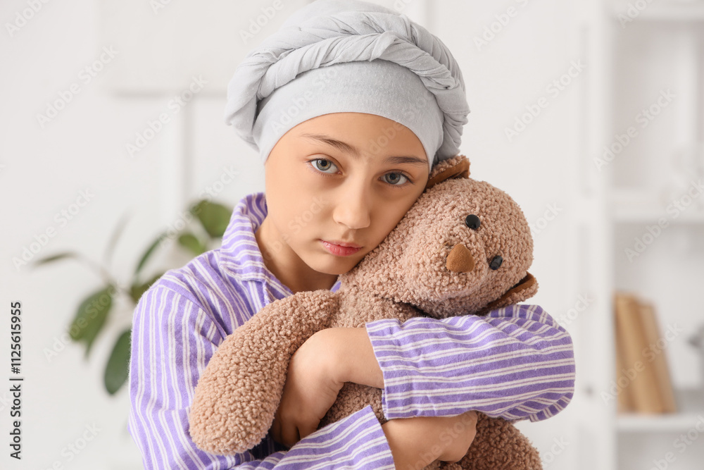 Sad little girl after chemotherapy with toy bear at hospital, closeup. Childhood cancer awareness concept Sad little girl after chemotherapy with toy bear at hospital, closeup. Childhood cancer awareness concept