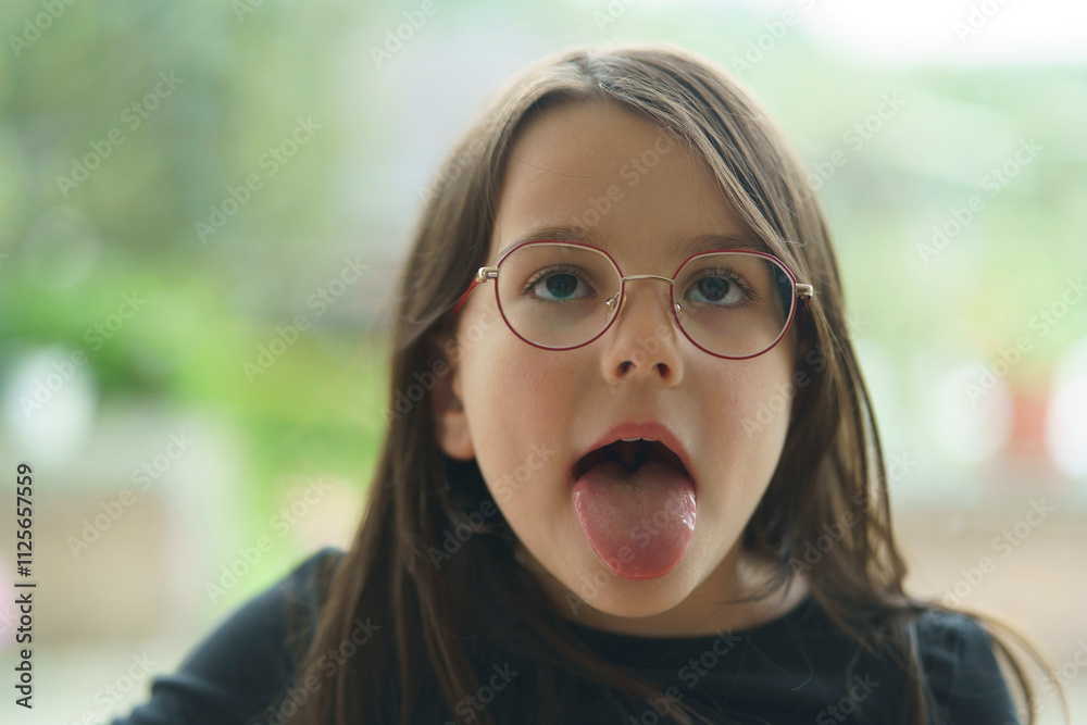 Little cute smiling girl with all her teeth in front of a big transparent window. Concept of healthy children's teeth Little cute smiling girl with all her teeth in front of a big transparent window. Concept of healthy children's teeth