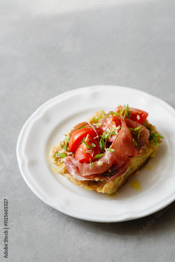 Belgian potato waffles served with ham, tomatoes and herbs with cutlery on a concrete background. Healthy breakfast, savory waffles