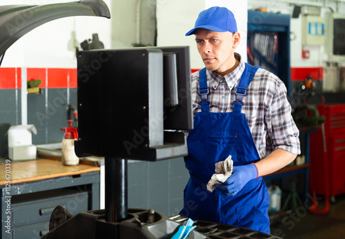 Confident european male technician ready to work with balancing machinery at workshop