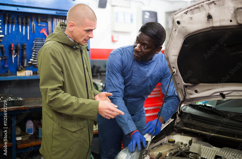 Two car mechanic diagnosing auto engine problem in auto service Two car mechanic diagnosing auto engine problem in auto service