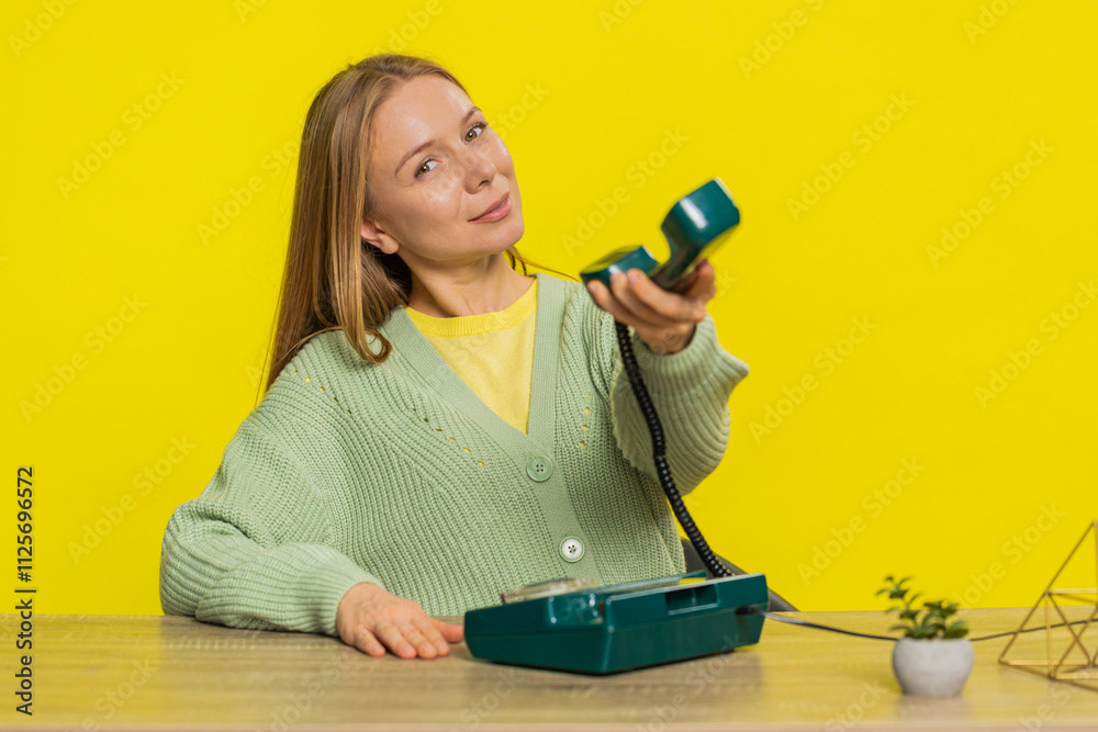 Call me. Woman looking at camera advertising phone call having conversation on wired old-fashioned retro telephone. Call center or support service operator helpline hotline. Girl on yellow background Call me. Woman looking at camera advertising phone call having conversation on wired old-fashioned retro telephone. Call center or support service operator helpline hotline. Girl on yellow background