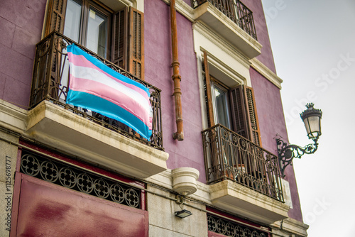 LGBT Trans Flag Hanging on the Railing of a Balcony on a Street in Support of LGTB Community. Madrid, Spain photo