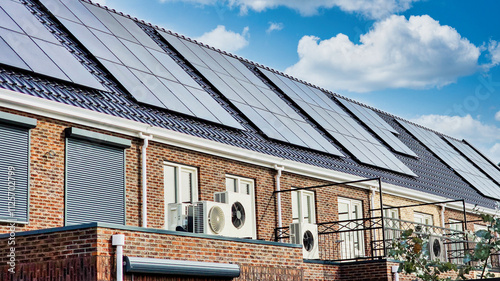 Foto Newly build houses with solar panels attached on the roof against a sunny sky